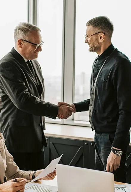 Handschlag zweier Unternehmer in einem hellen Büro